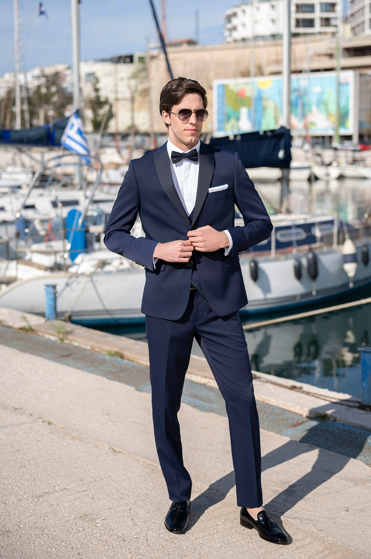 Ολόσωμη εμφάνιση με ανδρικό tuxedo σε μπλε του μεσονυχτίου με μαύρο σατέν πέτο και παπιγιόν και μαύρα λουστρίνι παπούτσια. Κλασικό black tie look